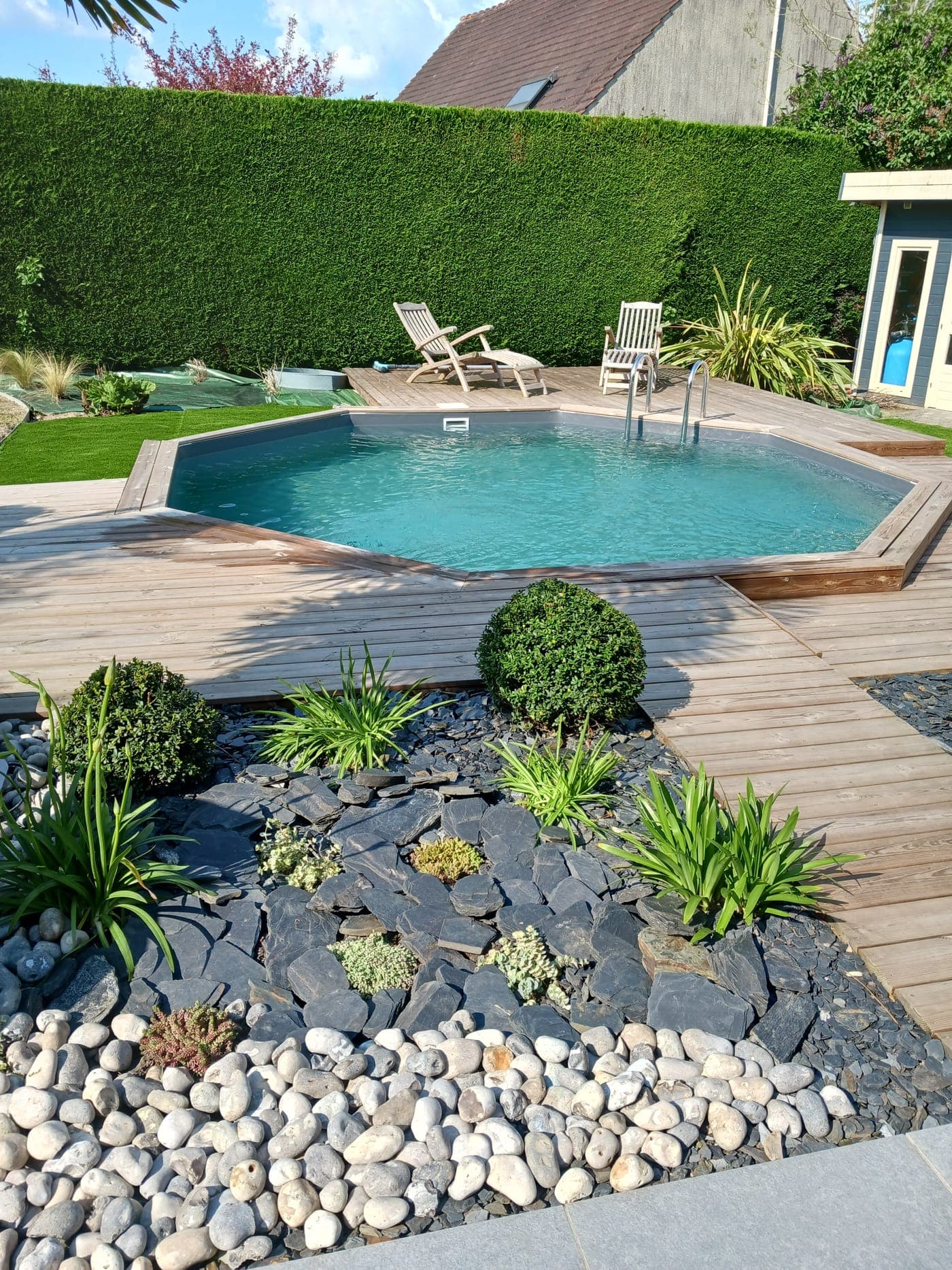Pergola bois sur-mesure avec galets décoratifs et plantation soignée